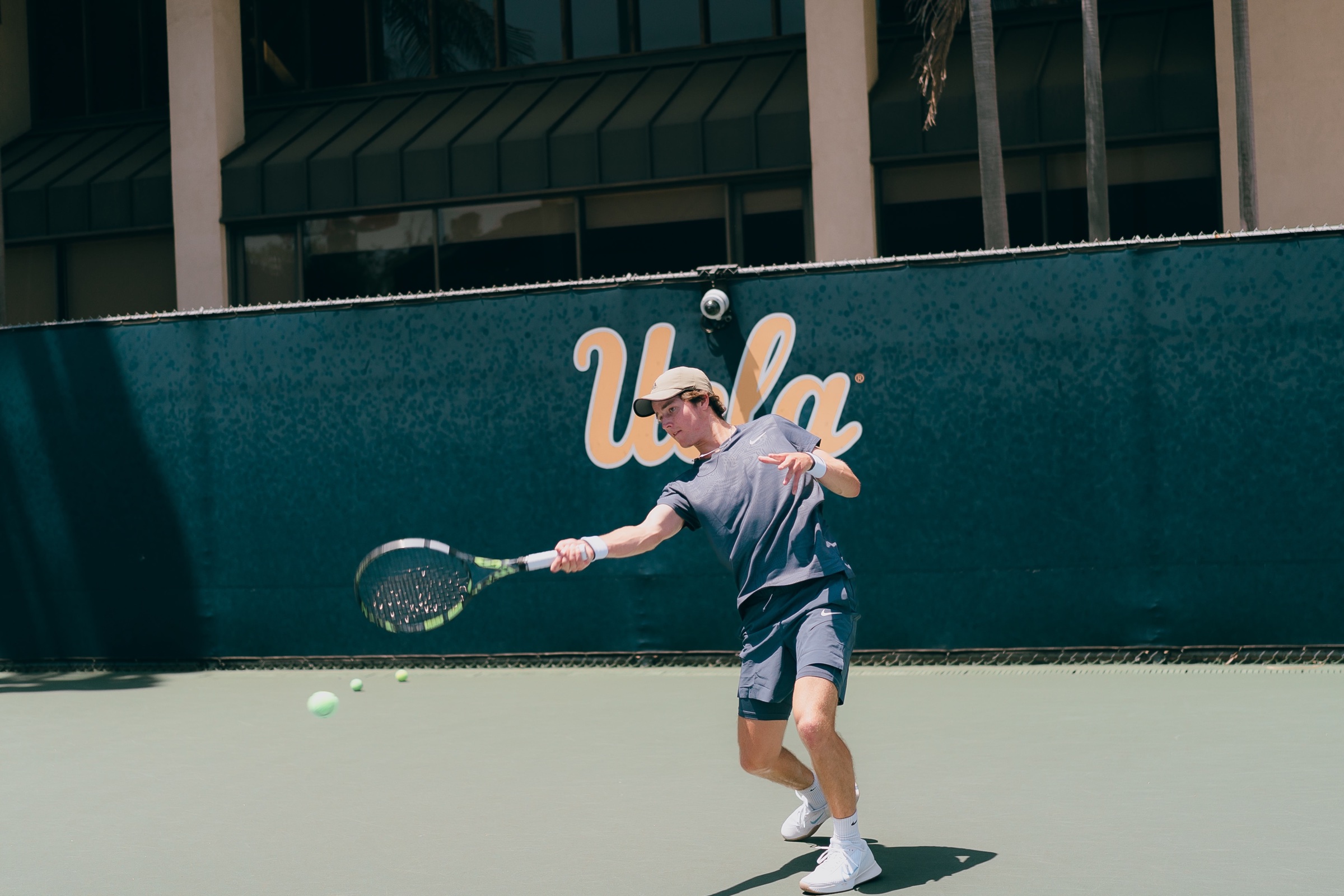Will Steinberg hitting a forehand on the UCLA tennis courts